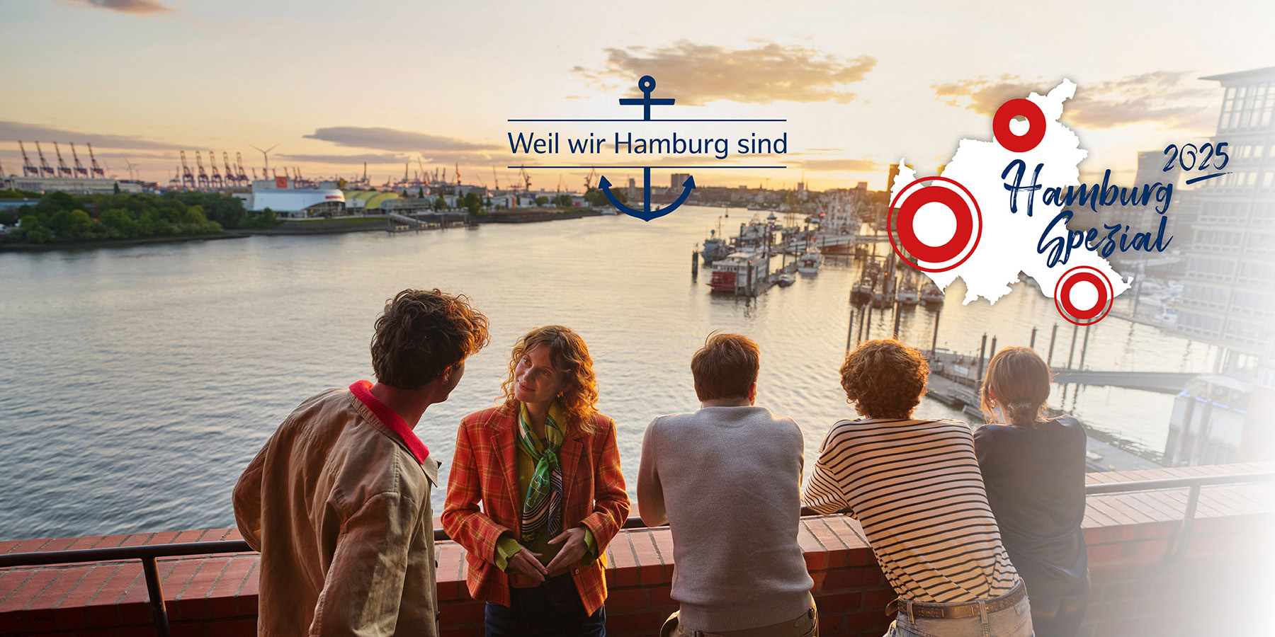 Eine Gruppe Menschen steht auf dem Balkon der Elbphilharmonie und schaut auf den Hafen.